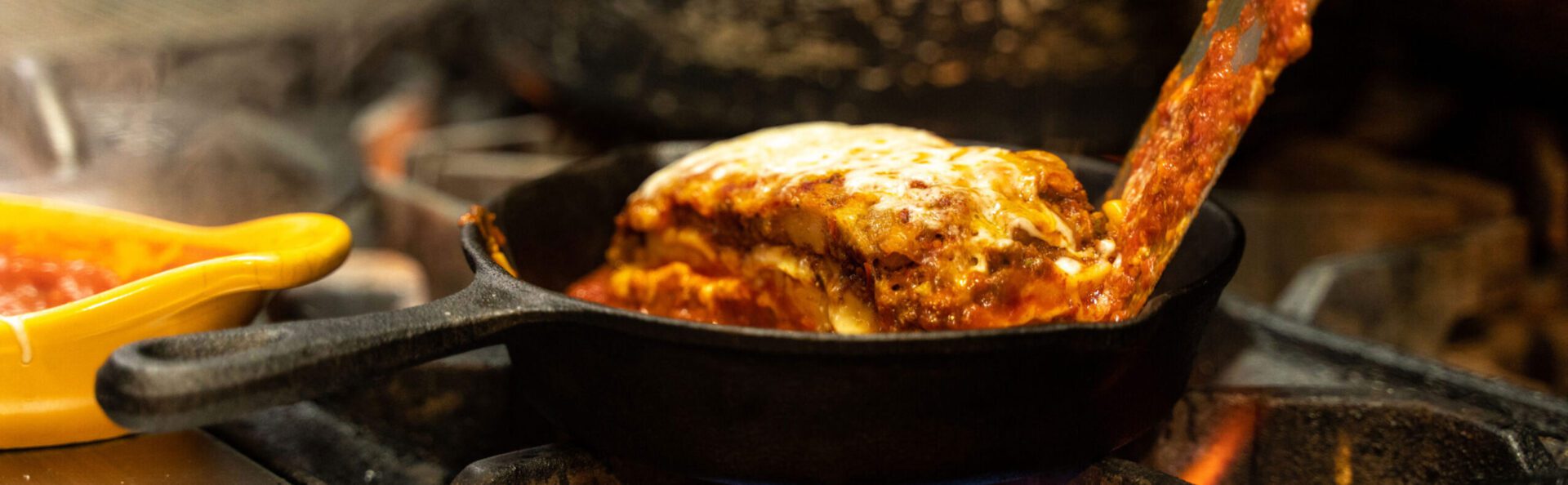 A close up of a piece of lasagna in a pan