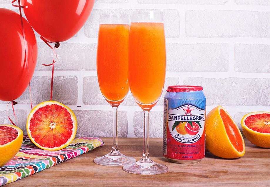 Two glasses of orange juice next to a can and grapefruit.