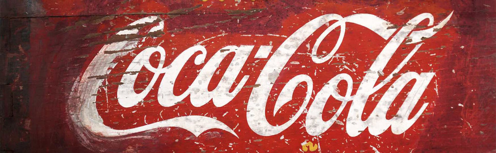 A close up of the coca cola logo on a wall