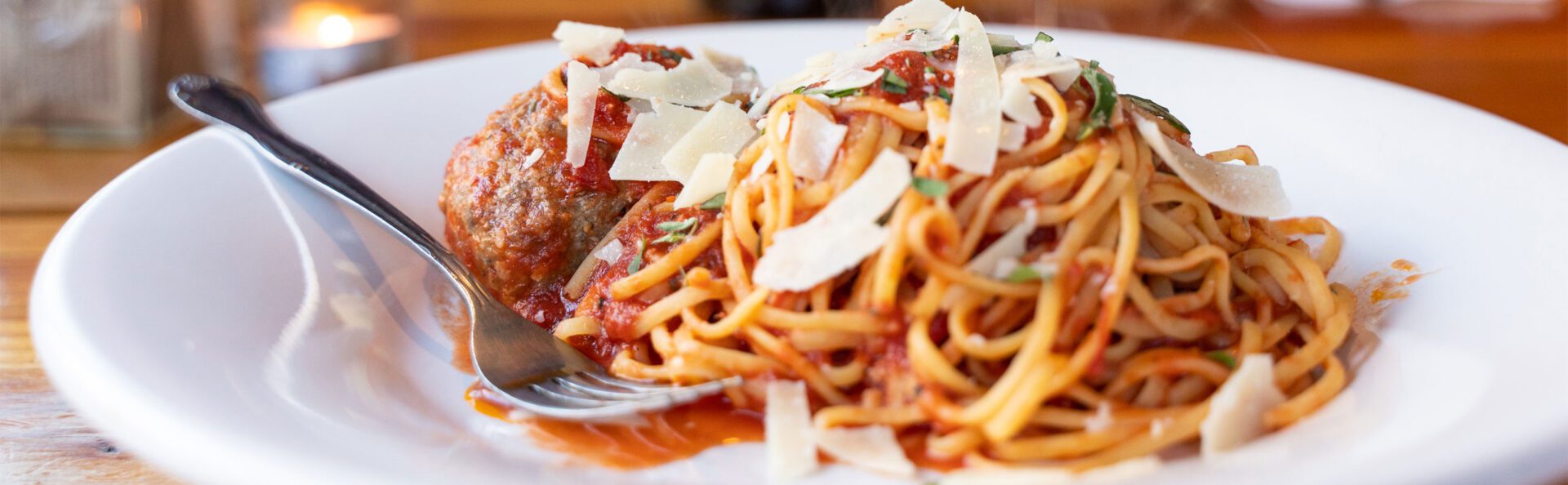 A plate of spaghetti and sauce with parmesan cheese.