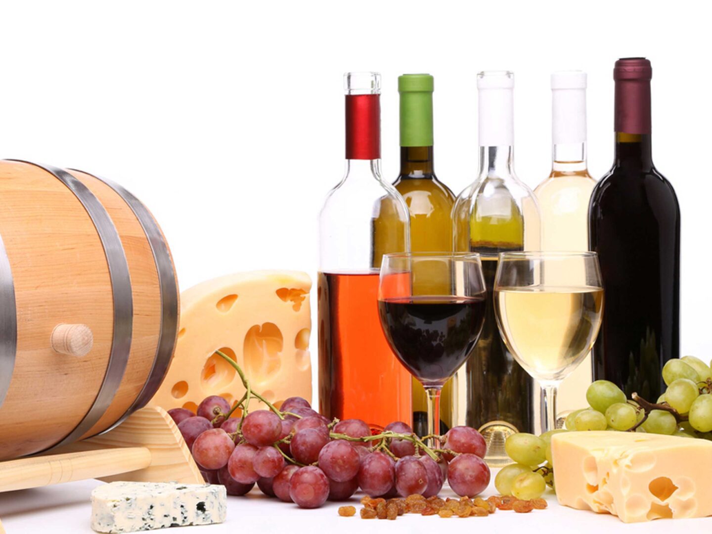A table topped with wine and cheese next to grapes.